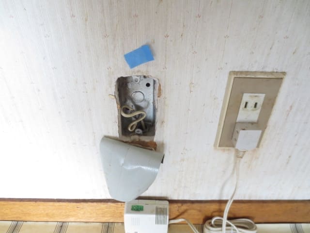 壁の器具が外れ、配線がむき出しになっている原状回復前の部屋の様子。想定外の修繕トラブルに直面した一棟マンションオーナーのリアルな体験を象徴する光景。